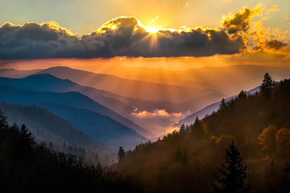 This image highlights expansive mountain ranges at sunset, with atmospheric clouds and a sense of serene grandeur. The view represents the outdoor adventure and exploration opportunities that await nearby, including hiking, photography, and moments of reflection in nature.